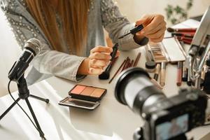 vrouw handen met wenkbrauw tint gel. vrouw schoonheid blogger maken een video recensie van kunstmatig producten. foto