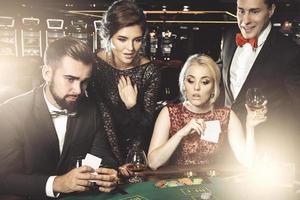 groep van jong rijk mensen spelen poker in de casino foto