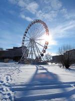 ferris wiel Krakau oog in de achtergrondverlichting tegen een blauw lucht met wolken Aan ijzig winter dag. verticaal foto. Krakau, Polen, Europa. foto