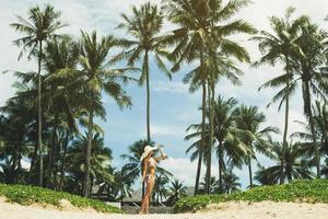 mooi vrouw Aan de strand met een palm bomen foto