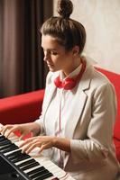 jong vrouw musicus spelen synthesizer Bij huis foto