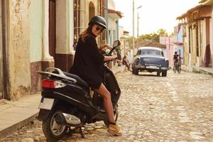 vrouw het rijden scooter door de oud stad straten foto