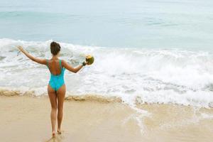 gelukkig vrouw met een kokosnoot Aan de strand foto