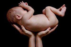 schattig pasgeboren baby aan het liegen in de moeder handen foto