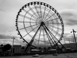 een groot ronde mooi ferris wiel, een panoramisch platform in een park Aan een tropisch zee warm zomer toevlucht met palm bomen tegen een blauw lucht foto