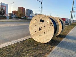 wikkelen van elektrisch kabel wond Aan een houten haspel, geïsoleerd in zwart rubber draad dichtbij omhoog foto