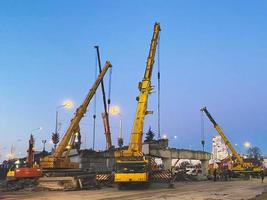 bouw van een gebroken brug Aan een bezig weg. bouw uitrusting Aan een sectie van de weg richt zich op een viaduct in de donker foto