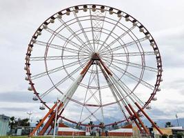 een groot ronde mooi ferris wiel, een panoramisch platform in een park Aan een tropisch zee warm zomer toevlucht met palm bomen tegen een blauw lucht foto