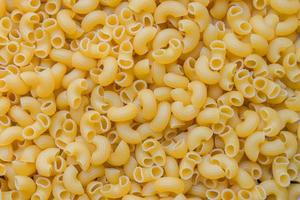 pasta achtergrond - top visie, rauw macaroni structuur achtergrond, dichtbij omhoog rauw macaroni pasta ongekookt heerlijk pasta voor Koken voedsel foto