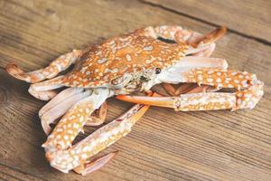 gekookt krab voedsel Aan tafel houten achtergrond - zeevruchten krab klauwen schaaldieren foto