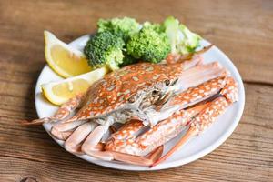 gekookt krab voedsel Aan wit bord zeevruchten Aan de tafel - salade krab klauwen schaaldieren foto
