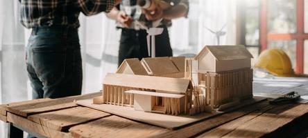 schaal model- huis Aan tafel met architecten. twee architecten maken bouwkundig model- in kantoor samen. naar het formulier een nieuw gebouwd in foto