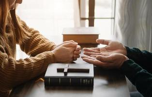 vrouw hand- met kruis .concept van hoop, vertrouwen, Christendom, geloof, kerk en bidden naar god. Aan de tafel foto