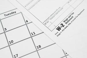 w-2 salaris en belasting uitspraak blanco leugens Aan leeg kalender bladzijde foto