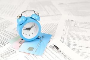 1040 individu inkomen belasting terugkeer het formulier en blauw alarm klok Aan credit kaarten foto