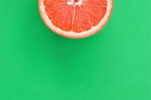 top visie van een een grapefruit plak Aan helder achtergrond in groen kleur. een verzadigd citrus structuur beeld foto
