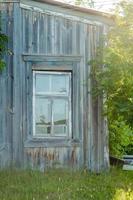 verlaten houten huis met een venster, zonder mensen foto
