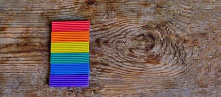 dichtbij omhoog van lgbt vlag tegen de licht houten achtergrond. lgbt regenboog kleuren van plasticine foto