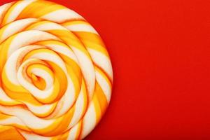 kleurrijk ronde lolly, Aan rood achtergrond. minimaal concept met kopiëren ruimte. foto