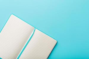 Open notitieboekje, dagboek met blanco en blanco Pagina's Aan een blauw achtergrond, top visie. foto