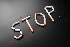 de opschrift hou op van sigaretten Aan een zwart achtergrond. hou op roken. de concept van roken doodt. motivatie opschrift naar stoppen roken, ongezond gewoonte. foto