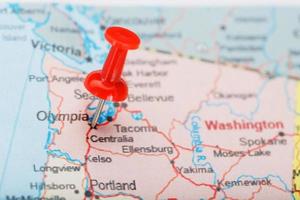 rood klerikaal naald- Aan kaart van Verenigde Staten van Amerika, Washington en gelijkstroom dichtbij omhoog kaart van Washington met rood tack foto