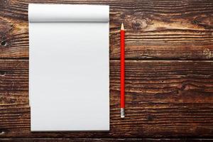 kladblok met rood potlood Aan een bruin houten tafel achtergrond, voor opleiding, schrijven doelen en daden