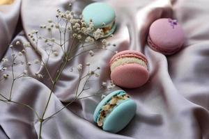 roze en mint franse bitterkoekjes of macarons cookies en een witte bloemen op een doek achtergrond. natuurlijke fruit- en bessenaroma's, romige vulling voor Valentijnsdag moederdag Pasen met liefdesvoedsel