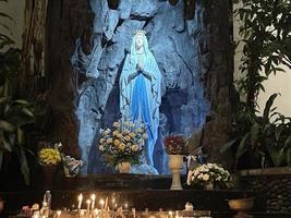 de grot van maagd Maria, standbeeld van maagd Maria in een rots grot kapel Katholiek kerk met tropisch vegetatie foto