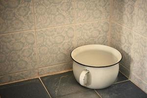 een oud urine pot in de badkamer foto