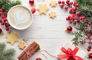 kop van latte koffie en Kerstmis decoratie Aan een wit houten achtergrond foto