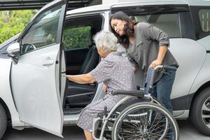 hulp en ondersteuning aziatische senior of oudere oude dame vrouw patiënt bereidt zich voor om naar haar auto te gaan. foto