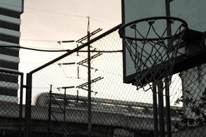 hoog hoek visie van oud basketbal hoepel met beweging wazig trein in de schemering lucht achtergrond foto