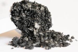 zwart lava zout gemorst van een theelepel foto