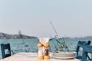 cafe tafel Aan de achtergrond van de zee, heet middag. achtergrond idee voor vakantie reclame of keuken opnieuw bekijken. weekend Bij zee foto