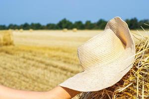 werken hoed van een boer Aan een hooiberg. landbouw concept.oogst concept foto