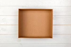 geopend bruin blanco karton doos Aan houten achtergrond, top visie foto