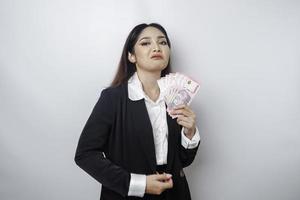 een portret als een jong zakenvrouw met een stack van geld in Indonesisch roepia in haar handen geïsoleerd door wit achtergrond foto