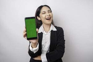 een gelukkig jong zakenvrouw is vervelend zwart pak, tonen kopiëren ruimte Aan haar telefoon geïsoleerd door wit achtergrond foto