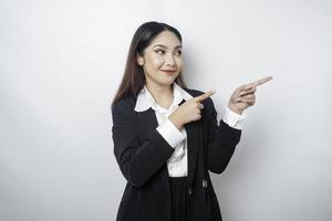opgewonden Aziatisch zakenvrouw vervelend zwart pak richten Bij de kopiëren ruimte naast haar, geïsoleerd door wit achtergrond foto