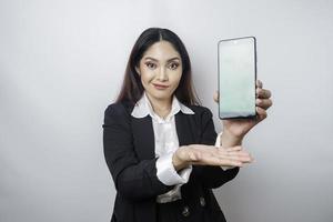 een gelukkig jong zakenvrouw is vervelend zwart pak, tonen kopiëren ruimte Aan haar telefoon geïsoleerd door wit achtergrond foto