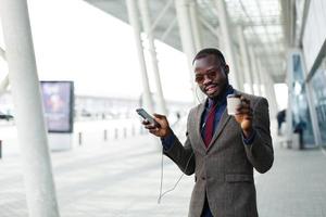 gelukkig Afro-Amerikaanse zakenman danst terwijl hij naar de muziek luistert foto
