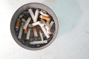 close-up brandende sigaret in asbak op tafel foto