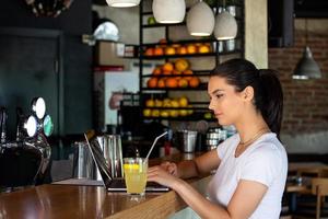 portret van mooi jong vrouw genieten van een drankje, mooi meisje nippen citroen sap in koffie winkel terras foto