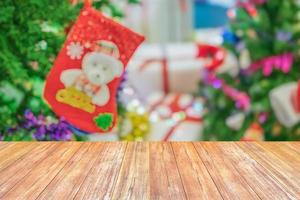 leeg hout tafel top met vervagen Kerstmis boom met bokeh licht achtergrond foto