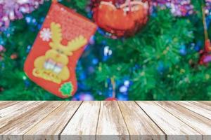 leeg hout tafel top met vervagen Kerstmis boom met bokeh licht achtergrond foto