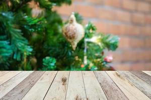 leeg hout tafel top met vervagen Kerstmis boom met bokeh licht achtergrond foto