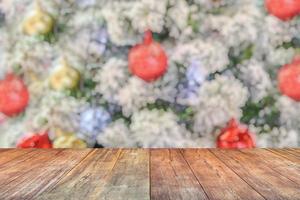 leeg hout tafel top met vervagen Kerstmis boom met bokeh licht achtergrond foto