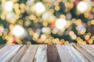 leeg hout tafel top met vervagen Kerstmis boom met bokeh licht achtergrond foto