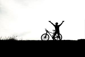 silhouet van een persoon rijden een fiets foto